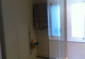 Mampara de dutxa a mida amb porta corredissa en vidre laminat. 